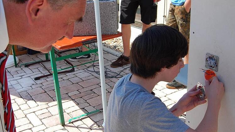 Fabian Diemer stellte den Beruf des Elektronikers vor. Er ist auch nach diesem Praktikum nicht sicher, ob es das Richtige für ihn ist. Schulleiter Hanna schaute dem Schüler interessiert über die Schulter.  Foto: Günther Straub