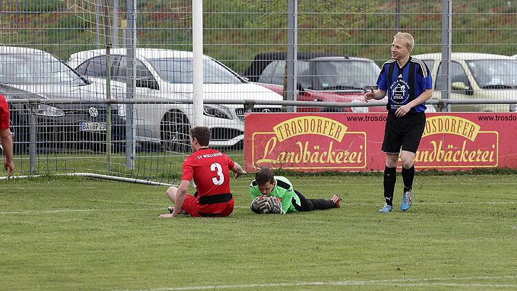 Der Ball ist sichere Beute für den SV-Torwart Daniel Reichhold; links Benjamin Brändlein, rechts der Bischberger Torjäger Martin Meinl-Götz