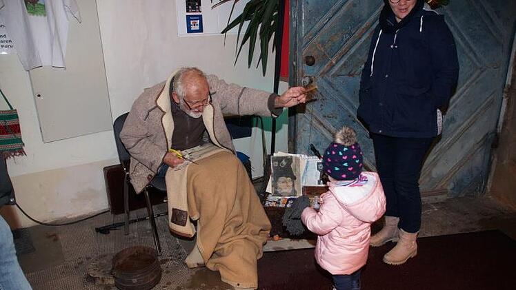 Alt und Jung kamen zusammen: Pater Andreas von den Salesianern spielt beim Don-Bsoco-Weihnachtsmarkt mit einem Kind. Foto: Joseph Beck