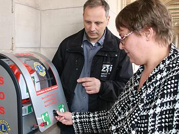 Unter Anleitung von Thomas Schreiner darf Annett Lüdecke das üben, was sonst nur im Notfall erlaubt ist und sofort zum Alarm führt: Den Defi entnehmen. Foto: Ralf Ruppert