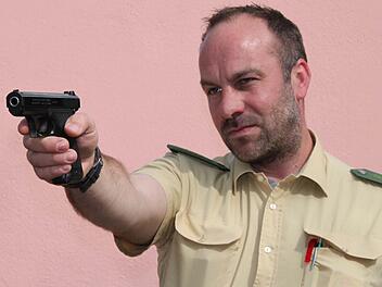 Die Dienstwaffe von Steffen Trabert ist natürlich nicht geladen. Der Polizeihauptmeister demonstrierte zehn Mädels, was alles zu einer Polizei-Ausrüstung gehört. Fotos: Ulrike Müller