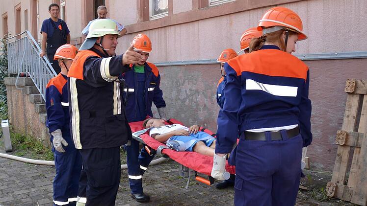 Wohnhausbrand: Die Bergung des Bewusstlosen ist geschafft. Der Stralsbacher Kommandant Bernd Müller gibt Anweisung. Im Hintergrund sind der Stralsbacher Jugendwart Christoph Kröckel und Kreisbrandmeister Klaus Preisendörfer zu sehen. Foto: Kathrin Kupka-Hahn