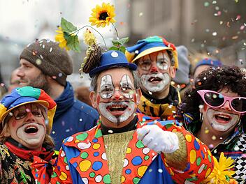 Bunt und Schrill geht es in der Faschingszeit zu: Besucher eines Faschingsumzugs werfen mit KonfettiSymbolbild: Tobias Hase dpa/lby