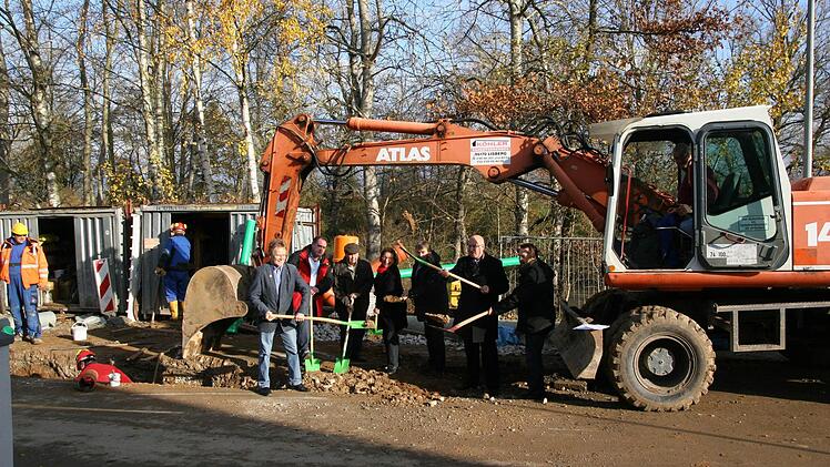 Spatenstich unter dem Schaufelbagger: Bürgermeister Klaus Homann und Angehörige der Fraktionen des Marktgemeinderats packen zusammen mit der Baufirma Köhler aus Lisberg sowie dem Bauingenieur Hans-Jürgen Sauer ein 320 000 Euro teures Abwasser-Projekt an. Foto: wb