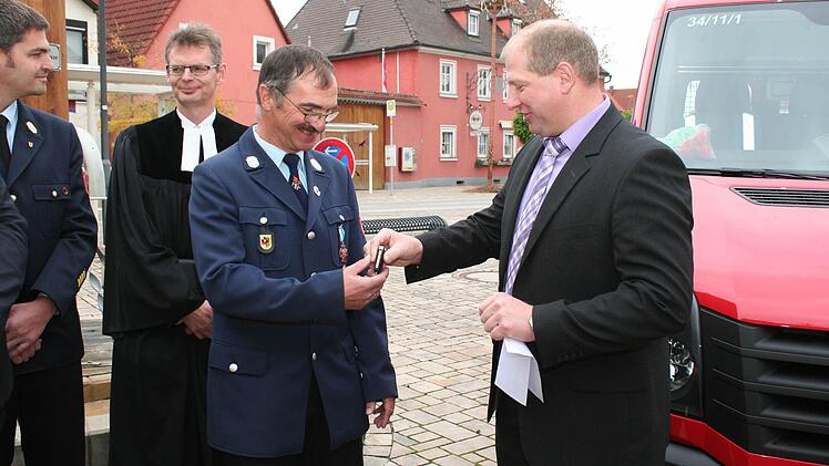 Bürgermeister Klaus Faatz (rechts) übergibt dem Kommandanten der Feuerwehr Mühlhausen, Reinhard Vogel, den Fahrzeugschlüssel. Im Bild von links: Kreisbrandrat Matthias Rocca, Pfarrer Andreas Steinbauer.