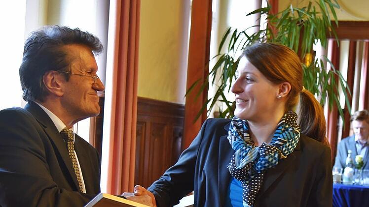 IHK-Präsident Friedrich Herdan überreicht eine Urkunde und den Geldpreis an Marina Reißenweber.