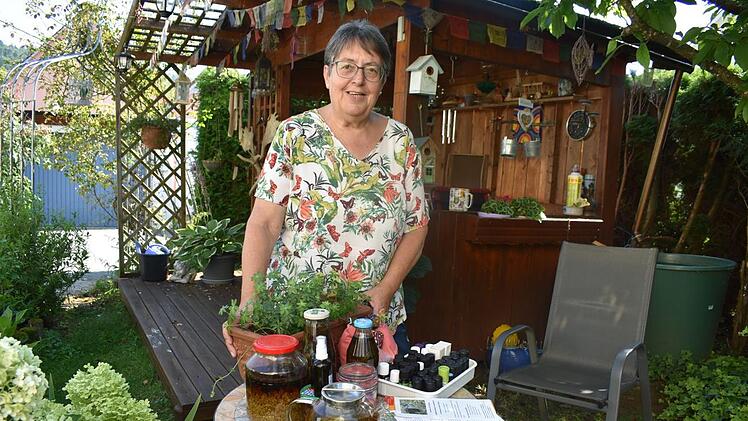 Irmgard Ginzel hat Öle, Tinkturen und Sirup selbst hergestellt. In dem Blumenkasten blüht Waldmeister.  Foto: Petra Malbrich