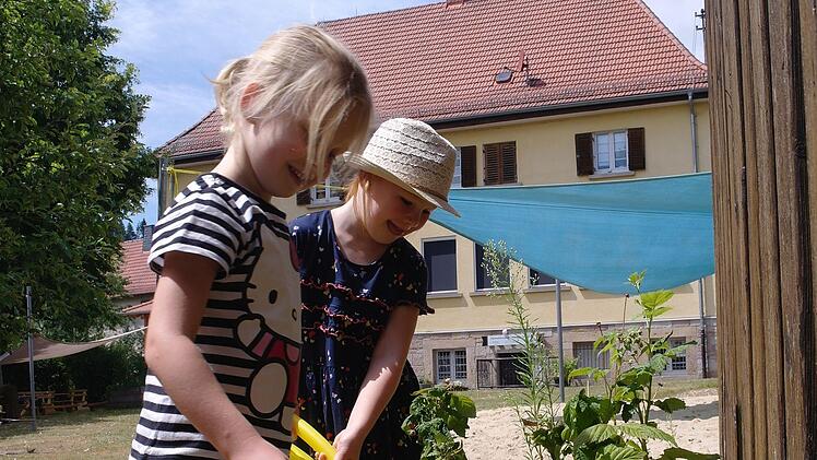 Sofia (vorne) und Ella helfen jeden Tag wie selbstverständlich im Kindergarten beim Gießen.
