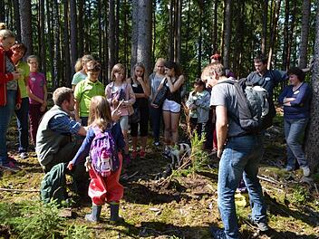 Förster Michael Sautter (sitzend) erklärte den Kindern auf interessante Weise die vorkommenden Baumarten. Foto: Gartenbauverein
