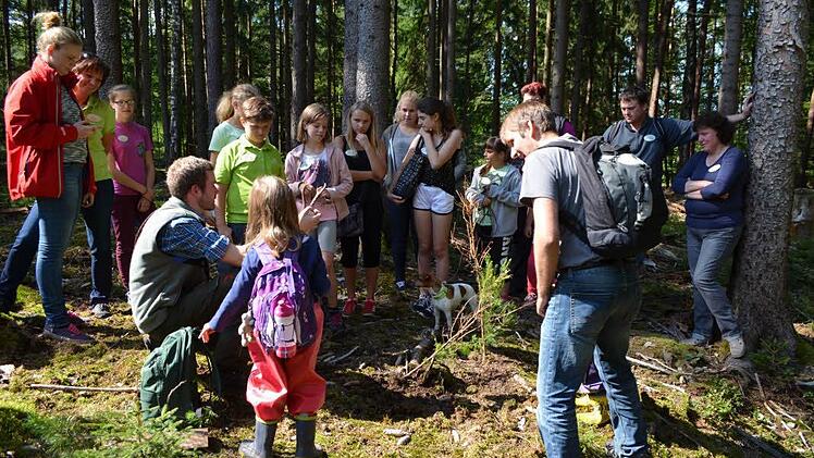 Förster Michael Sautter (sitzend) erklärte den Kindern auf interessante Weise die vorkommenden Baumarten. Foto: Gartenbauverein