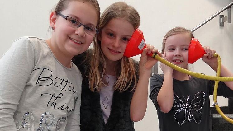 Kommunikation vom Obergeschoss bis in den Keller mit dem Sprachschlauch (v.l.nr.): Lena Trinkerl, Pia Kühnel und Hannah Sperber aus der Klasse 4d sind begeistert, wie gut dieses Telefon quer durch das Schulhaus funktioniert.