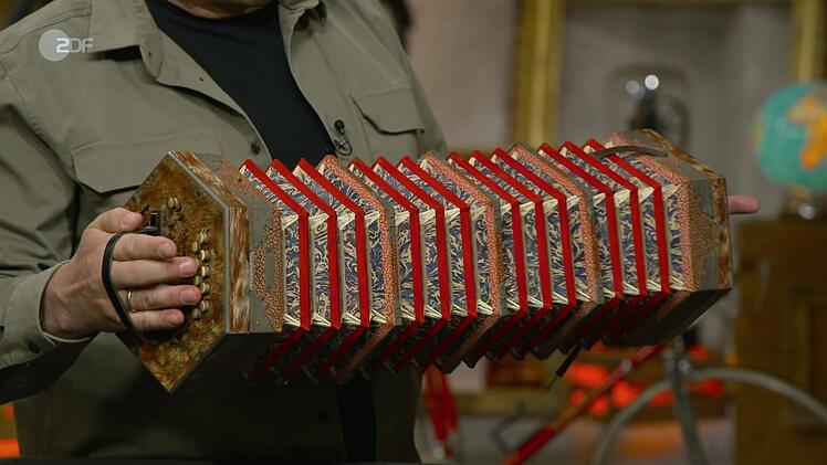 Made in Sachsen, stellte Experte Deutschmanek fest, als er den Stempel auf dem Instrument entdeckte. Die Konzertina stammte von der Traditionsfirma Meinel & Herold aus Klingenthal - und war mit ihren Details ein echtes Schmuckstück: Ein Leinenblasebalg mit Marmorpapier, Eisenbeschlägen, Lederriemen und Knöpfen aus Bein.