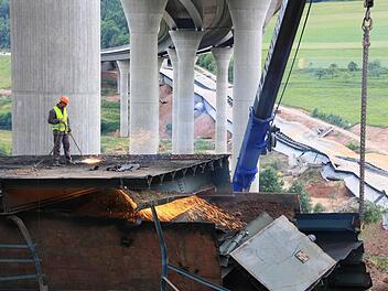 Unter der neuen Sinntalbrücke haben gestern Mitarbeiter der Firma Plannerer die alte Brücke in Teile geschnitten. Fotos: Evelyn Schneider, Paul Ziegler, Ralf Ruppert