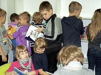 Lea Deuerling (links) und Lena Klinger haben es sich auf dem gelben Sitzsack in der neuen Bibliothek gemütlich gemacht, Luca Ströhlein schaut, was die beiden lesen.  Foto: Susanne Deuerling