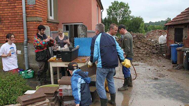 Die Familie Förster bei den Aufräumarbeiten in Poppenlauer. Foto: Heike Beudert