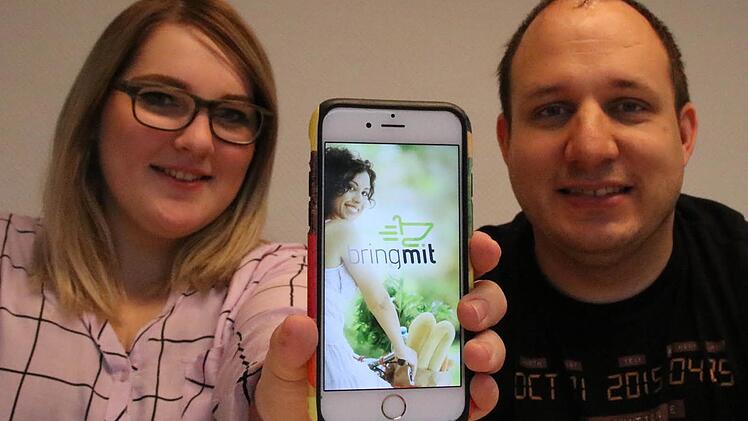 Studentin Camilla van Veen und Software-Entwickler Andreas May zeigen die Startseite der Bring-Mit-App, die Pulsis Media entwickelt hat. Aktuell läuft ein Textlauf im Rahmen einer Bachelorarbeit. Foto: Ralf Ruppert