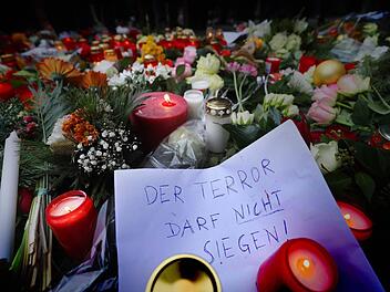 Kerzen und Blumen liegen am 20.12.2016 in Berlin am Ort des m&ouml;glichen Anschlags. Bei einem m&ouml;glichen Anschlag war ein Unbekannter am Montag (19.12.) mit einem Lastwagen auf einen Weihnachtsmarkt an der Ged&auml;chtniskirche gefahren. Auf dem Plakat steht: "Der Terror darf nicht siegen". Foto: Michael Kappeler/dpa