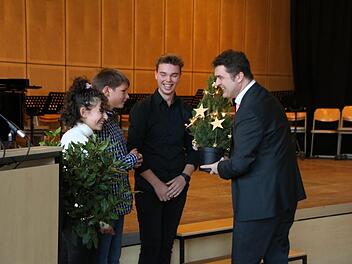 Fadya Soda, Frederik Dürr und Jascha Bauer-Heilmann von der SMV überreichen Peter Rottmann einen kleinen Weihnachtsbaum. Thomas Malz