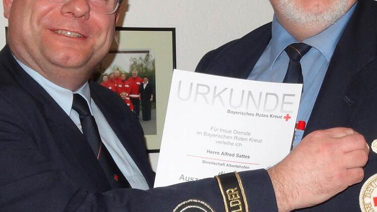 Kreisgeschäftsführer Harald Erhard gratuliert dem neu gewählten Bereitschaftsleiter Alfred Sattes und ehrt ihn gleichzeitig für 35 Jahre uneingeschränktes, ehrenamtliches Engagement bei der Sanitätsbereitschaft mit einer Urkunde und einer Dienstzeitspange.