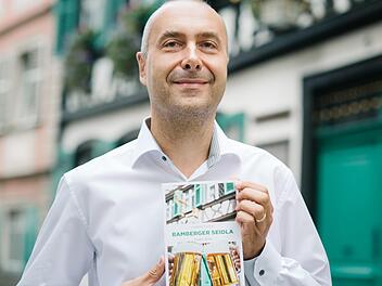 Autor Harry Luck mit seinem neuen Buch vor authentischer Kulisse in der Sandstraße.  Foto: Hendrik Steffens
