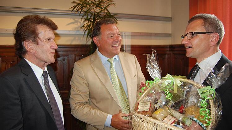 IHK-Präsident Friedrich Herdan (links) und IHK-Hauptgeschäftsführer Siegmar Schnabel (rechts) bedankten sich bei Martin Fuchs mit einem Coburg-Präsentkorb. Foto: Oliver Schmidt
