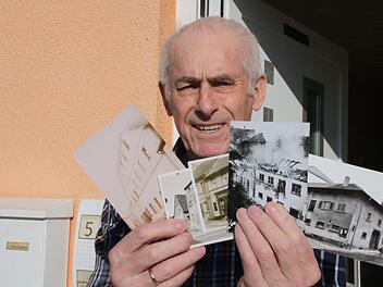 Das Hammelburger Urgestein Josef Kirchner erinnert sich noch gut an den fr&uuml;heren Bullenstall am Viehmarkt. Hier zeigt der 85-J&auml;hrige historische Aufnahmen aus seinem gro&szlig;en Bilder-Fundus.