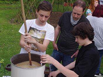 Markus und Max (von links) rühren die Maische für das "erste Küpser Schulbier". Die Temperatur muss rund 72 Grad betragen. Foto: Heike Schülein