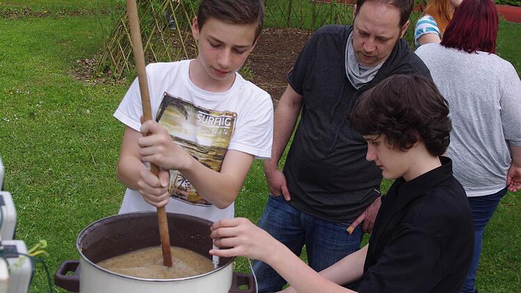 Markus und Max (von links) rühren die Maische für das "erste Küpser Schulbier". Die Temperatur muss rund 72 Grad betragen. Foto: Heike Schülein