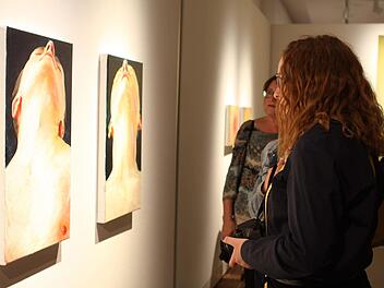 Besucher der Vernissage vor zwei Bildern von Cornelius Völker Michael Wunder
