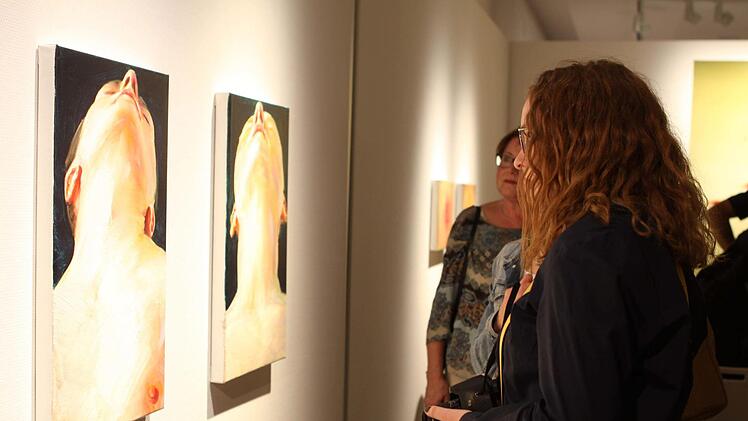 Besucher der Vernissage vor zwei Bildern von Cornelius Völker Michael Wunder