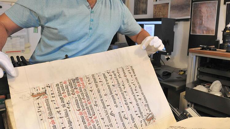Vorsichtig platziert Fotograf Gerald Raab das wertvolle Buch, um es ablichten zu können. Foto: Staatsbiliothek Bamberg