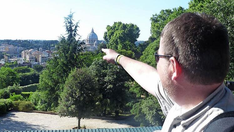 Michael Erhart zeigt auf den Mittelpunkt der katholischen Kirche: den Vatikan mit dem Petersdom. Der Pfarrer steht auf Gianicolo, einer Anhöhe in Rom, die eine tolle Aussicht über die ewige Stadt bietet.  Foto: Klaus Schmitt