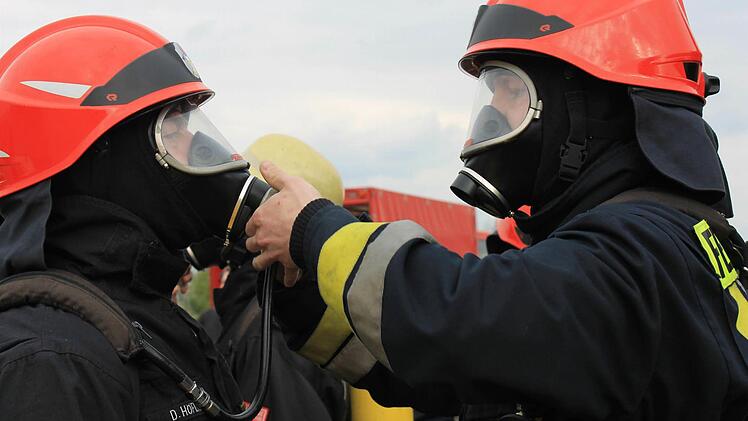 Vor dem Einsatz stecken sie sich gegenseitig die Sauerstoffgeräte an.