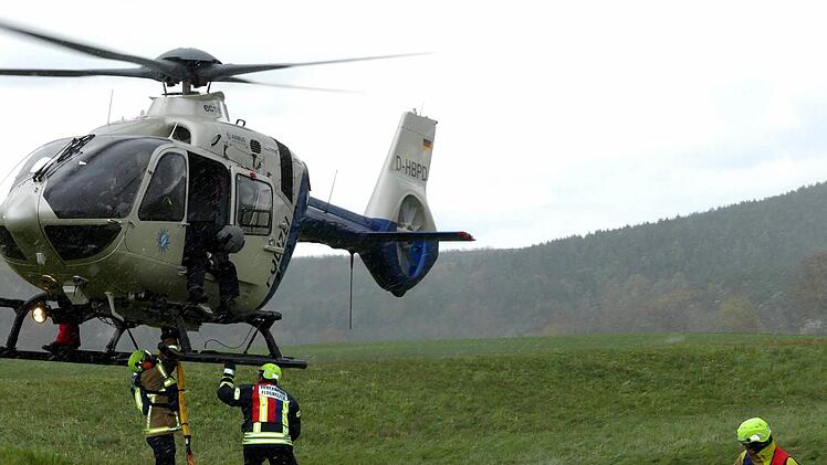 Flughelfer bringen die Last am Hubschrauber an