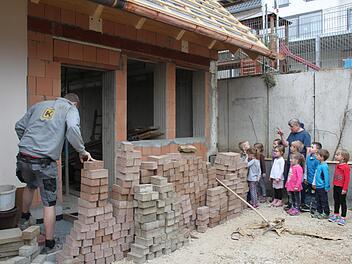 Der Garderobenbereich in der Weismainer Kita "Kinderzeit" wird erweitert. Zusammen mit Einrichtungsleiterin Elfi Bienlein schauen die Kleinen den Handwerkern bei der Arbeit über die Schulter. Foto: Stephan Stöckel