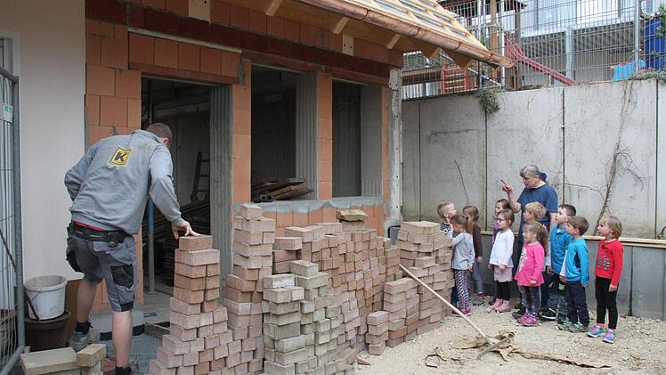 Der Garderobenbereich in der Weismainer Kita "Kinderzeit" wird erweitert. Zusammen mit Einrichtungsleiterin Elfi Bienlein schauen die Kleinen den Handwerkern bei der Arbeit über die Schulter. Foto: Stephan Stöckel