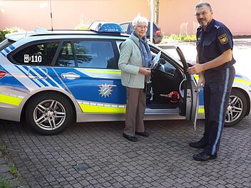 Galant hält Herbert Markert (rechts) der 84-jährigen Sieglinde Leiding die Autotür auf. Mit dem Streifenwagen chauffierte der Bad Brückenauer Polizeichef die Seniorin anschließend zur Kfz-Zulassungsstelle, wo nach freiwilliger Entscheidung ihre Fahrerlaubnis entwertet wurde. Foto: Rolf Pralle