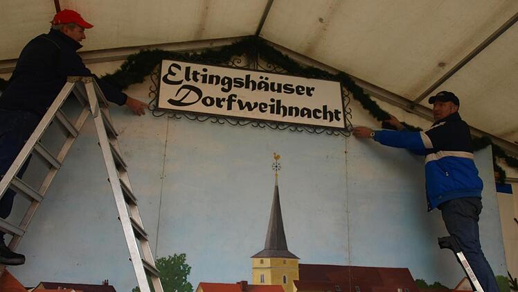 Michael Hoch (links)  und Alois Schott schmücken die Weihnachtsbühne.