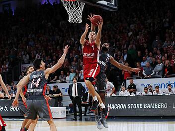 Fabien Causeur (M.) ist am Münchner Reggie Redding (r.) vorbeigezogen und schließt am Korb ab; links Nihad Djedovic, dahinter Maxi Kleber. Foto: Daniel Löb
