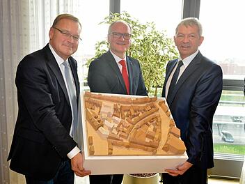 OB Starke, Stephan Kirchner und Johann Kalb (v.l.) präsentieren das Modell des Bauprojekts: Helles Holz steht für die neuen Gebäude.  Foto: RR