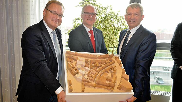OB Starke, Stephan Kirchner und Johann Kalb (v.l.) präsentieren das Modell des Bauprojekts: Helles Holz steht für die neuen Gebäude.  Foto: RR