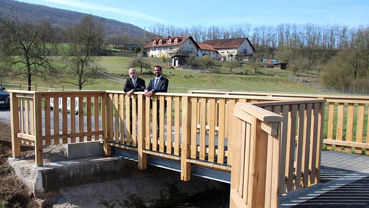 Bürgermeister Kay Blankenburg und Jan Voll, der Leiter des städtischen Bauamtes, sind am Freitagvormittag die ersten, die das neue Bauwerk über den Arnshäuser Lollbach betreten dürfen. Auffällig ist das hohe Geländer. Es soll vor allem die Radfahrer schützen.  Foto: Kathrin Kupka-Hahn