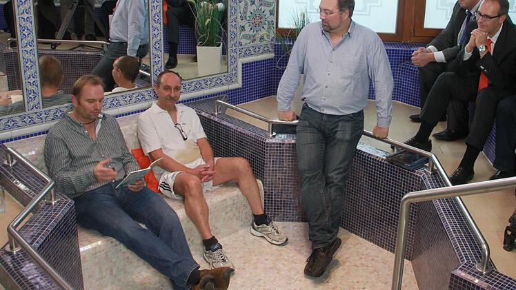 Lokaltermin in der Piscine: Helmut Vorndran (links) liest aus seinem druckfrischen "Thermentod"; Saunameister Peter Zillig (Mitte), einer der Protagonisten des Krimis, und Verleger Markus Raupach hören zu. Das kaffeegetränke Hemd von Peter Zillig ist übrigens Absicht, es gehört zur Eingangsszene des Krimis. Fotos: Matthias Einwag