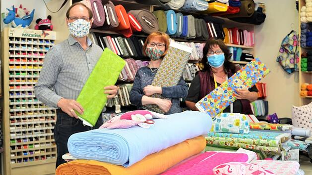 Die Inhaber von N&auml;hmaschinen Fugmann Peter und Katjana Oesterlein (von links) und Mitarbeiterin Sabine Seelow haben alle H&auml;nde voll zu tun: Stoffe f&uuml;r Masken sind gefragt wie nie. Foto: Sandra Hackenberg