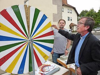 Pfarrer Hans-Michael Dinkel bediente auch das Glücksrad. Mit im Bild Pfarrgemeinderat Christian Fiedler  Foto: Gerd Fleischmann