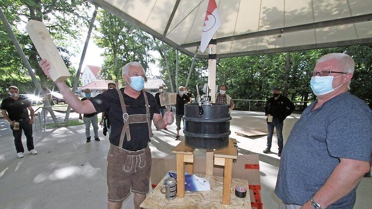 Jürgen Gumbrecht haut den Hammer auf ein Kantholz, dann wird mit moderner Zapfanlage angestochen. Die Kerwasburschen beobachten den "hochoffiziellen Akt" aus entsprechender Entfernung. Fotos: Michael Busch