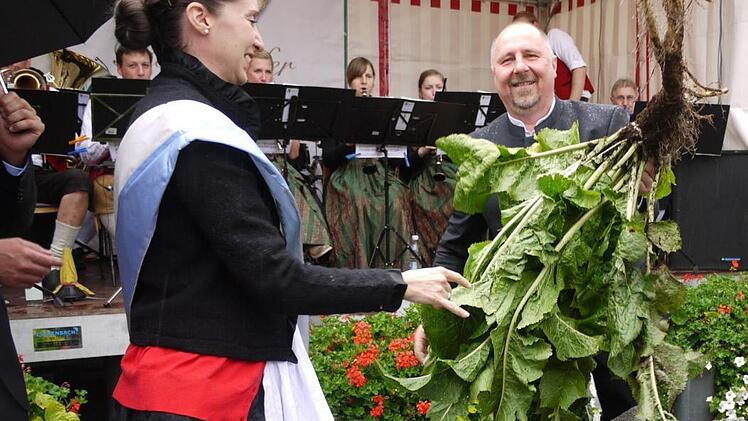 Isabella I. mit Bürgermeister Andreas Galster (oben links) reißen eine Krenstaude aus