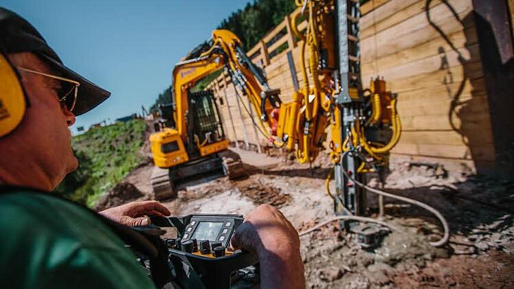Olaf Eckhardt steuert das Kettenfahrzeug mit dem großen Bohrer unterhalb der B 85. Die Holzwand hält den Schutt zurück.  Fotos: Hendrik Steffens