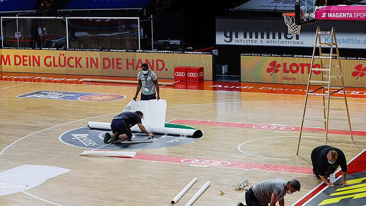 Ebenso werden die Werbeaufkleber an der Grundlinie für das nächste Spiel vorbereitet. Foto: Daniel Löb/Pool
