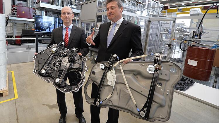Sieht ähnlich aus, wiegt aber deutlich weniger: Als erster Autozulieferer stellt Brose Türsysteme aus glasfasermattenverstärktem Kunststoff her. Michael Swoboda (links), Werkleiter in Hallstadt, zeigt einen Leichtbauträger aus dem innovativem Werkstoff. Kurt Sauernheimer, Geschäftsführer Türsysteme der Brose-Gruppe, hält noch ein Produkt aus Metall in der Hand, das heute nicht mehr gefertigt wird. Foto: Ronald Rinklef